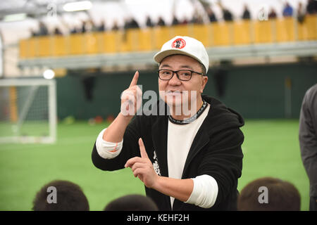 Commentateur de football chinois Dong Lu 'coaching' sous les garçons Football Chine 9 5 football équipe sur leur tournée au Royaume-Uni Banque D'Images