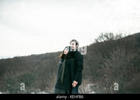 Couple caucasien debout sur la colline et reposant Banque D'Images