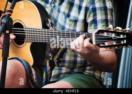 Homme assis et jouant de la guitare Banque D'Images