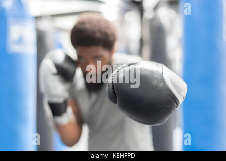 Portrait de l'homme noir portant des gants de boxe dans le gymnase Banque D'Images