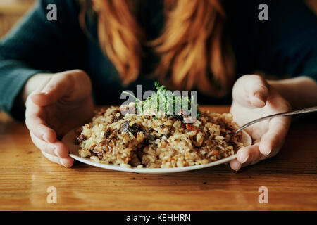 Mains de la femme tenant une assiette de riz Banque D'Images