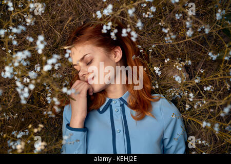 Femme caucasienne qui pond dans le champ de fleurs sauvages Banque D'Images