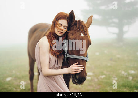 Caucasian woman petting horse Banque D'Images