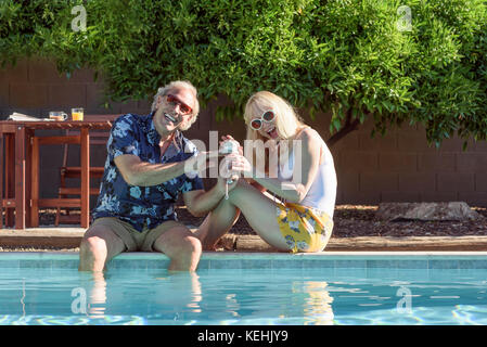 Couple caucasien souriant près de la piscine Banque D'Images