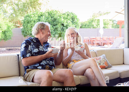 Couple caucasien manger des bols de fruits Banque D'Images