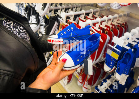 Mains d'Caucasian woman holding sneakers en magasin Banque D'Images