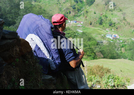 Trekker en faisant une pause sur le Sanctuaire de l'Annapurna trek, au Népal. Banque D'Images