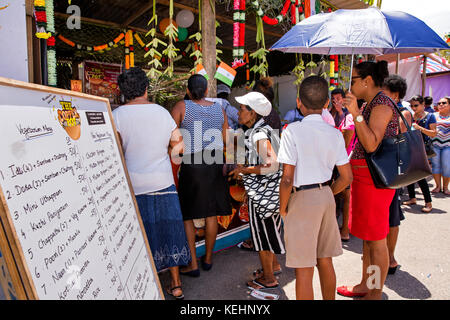 Les Seychelles, Mahe, l'Inde, jour de la file d'attente des clients en dehors de marmite en cuivre Indian food Banque D'Images