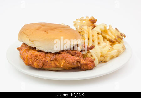 Sandwich au poulet frit sur du pain avec waffle chips servis sur une plaque de papier blanc. Banque D'Images