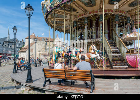 Caroussel avec de petites filles à cheval et les parents en attente Banque D'Images