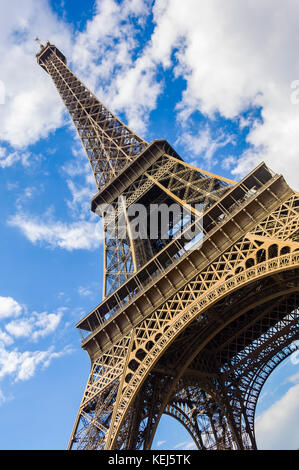 Résumé de la Tour Eiffel à Paris, contre un ciel nuageux bleu, encadré de près ci-dessous et coudée jusqu'fortement. Banque D'Images