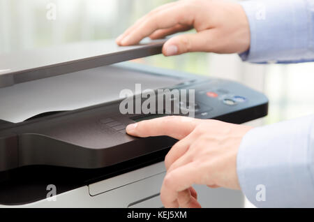 Appuyer sur le bouton à la main sur le panneau de l'imprimante laser scanner imprimante. copie de bureau Fournitures machine concept start Banque D'Images
