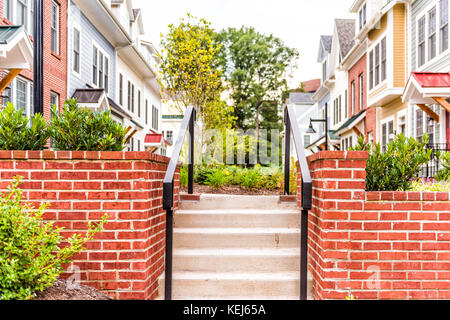 Rangée de couleurs, rouge, jaune, bleu, blanc, vert maisons résidentielles peint, les maisons, les maisons avec jardin patio de brique entrée escalier en été Banque D'Images