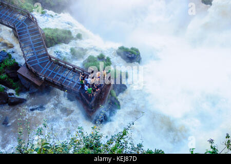 Puerto Iguazu, Argentine - le 19 septembre 2009 : les touristes dans le circuit de refroidissement de la pulvérisation des chutes d'Iguazu puissant, dans le parc national d'Iguazu à la frontière de Banque D'Images