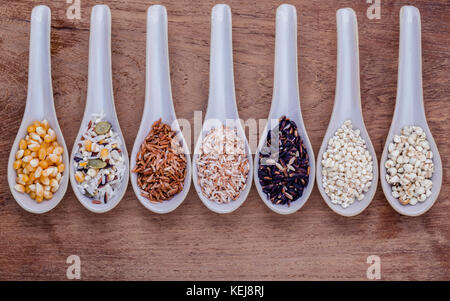 Assortiment de riz thaïlandais traditionnel en cuillère sur fond de bois. Le repas riche en fibres alimentaires et de la vitamine e pour des aliments sains et diététiques. Banque D'Images