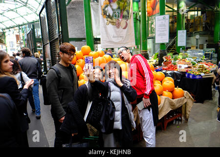 Les touristes chinois en tenant, selfies Borough Market, SE1, Londres, Royaume-Uni Banque D'Images