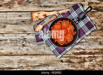 Les boulettes à la sauce tomate dans une poêle sur une table en bois, vue du dessus, style rural country style. Banque D'Images