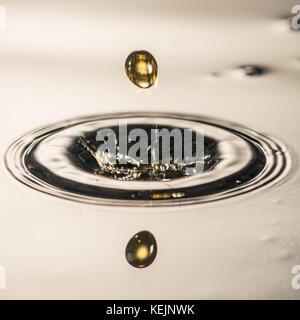 Une goutte d'eau tombe dans la surface d'un bassin d'eau. Banque D'Images