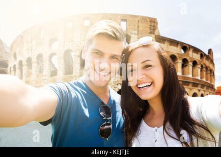 Portrait d'un jeune couple heureux en face de coliseum Banque D'Images