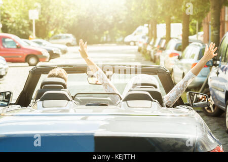 Vue arrière du couple de jeunes mariés dans la voiture Banque D'Images