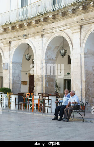 Le vieil homme assis sur un banc en Martina Franca, Pouilles, Italie Banque D'Images