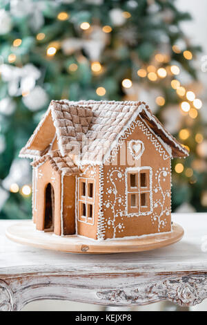 Gingerbread House sur feux de flou artistique de sapin décoré chrismtas Banque D'Images