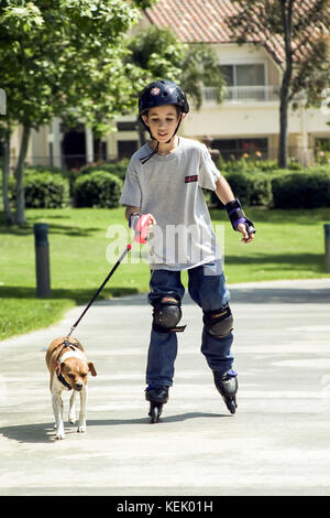 Jeune roller avec chien qui court en laisse chien de tête profitant de l'été activités santé vue avant USA © Myrleen Pearson Banque D'Images