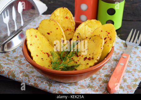 Les moitiés de pomme de terre cuite au four avec des épices et l'huile d'olive. une alimentation saine notion de vie méditerranéen. Banque D'Images