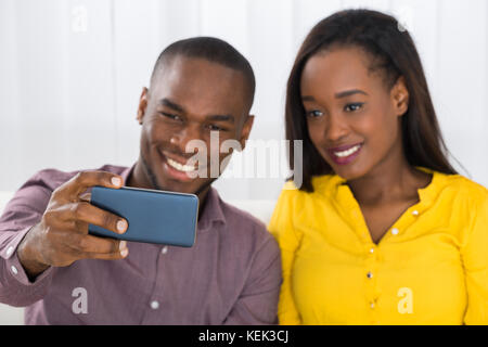 Portrait of young couple heureux de prendre un téléphone mobile avec des selfies Banque D'Images