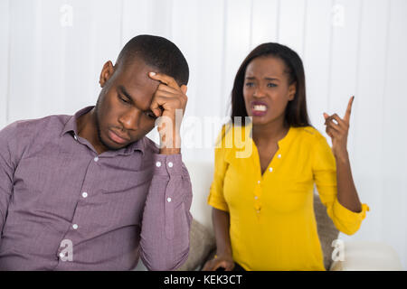 Jeune femme malheureuse having argument avec l'homme à la maison Banque D'Images