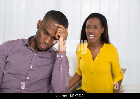 Jeune femme malheureuse having argument avec l'homme à la maison Banque D'Images