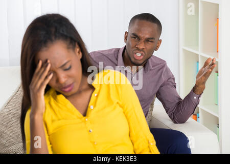 Malheureux Jeune homme Having Argument avec Woman at Home Banque D'Images