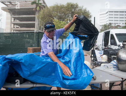 21 octobre 2017 - West Palm Beach, Floride, États-Unis - Fred Markwith, 70, jette une bâche sur sa table produit pour le protéger de la pluie à l'Ouest Palm Beach et marché aux puces d'Antiquités au centre-ville de West Palm Beach, en Floride, le samedi 21 octobre 2017. Des centaines de résidents du comté de Palm Beach essuyé pluie intermittente pour parcourir une variété d'antiquités au marché. (Crédit Image : © Andres Leiva/Le Palm Beach Post via Zuma sur le fil) Banque D'Images