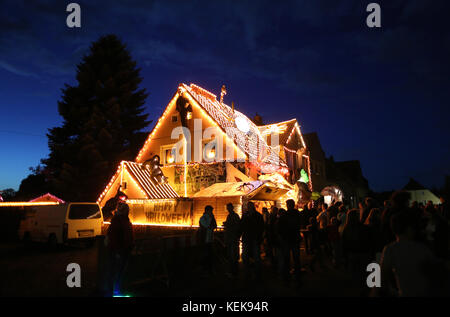 Hamm, Allemagne. 21 octobre 2017. Les visiteurs jettent un coup d'œil à la maison dite d'halloween de Gerd Willenberg à Hamm, en Allemagne, le 21 octobre 2017. Sa maison a été décorée avec des figures effrayantes pour Halloween depuis neuf ans. Jusqu'au 1er novembre, têtes réduites, squelettes et morts-vivants marchent pour effrayer les visiteurs. Crédit : INA Fassbender/dpa/Alamy Live News Banque D'Images