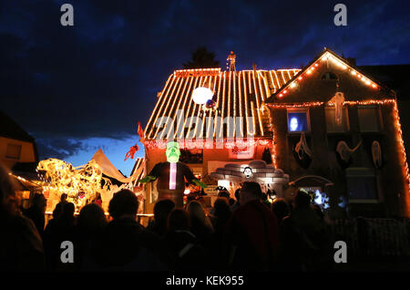 Hamm, Allemagne. 21 octobre 2017. Les visiteurs jettent un coup d'œil à la maison dite d'halloween de Gerd Willenberg à Hamm, en Allemagne, le 21 octobre 2017. Sa maison a été décorée avec des figures effrayantes pour Halloween depuis neuf ans. Jusqu'au 1er novembre, têtes réduites, squelettes et morts-vivants marchent pour effrayer les visiteurs. Crédit : INA Fassbender/dpa/Alamy Live News Banque D'Images