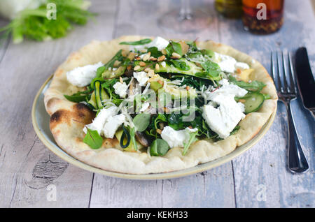 Pizza garnie de fromage feta et salade Banque D'Images