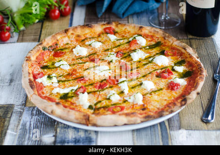 La tomate et mozzarella pizza garnie de pesto Banque D'Images