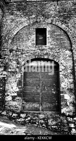 Porte en bois avec mur de brique en toscane, italie Banque D'Images