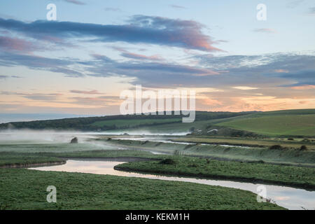 Beau lever de paysage au fil de la campagne anglaise avec qui traverse lentement la rivière à travers champs Banque D'Images