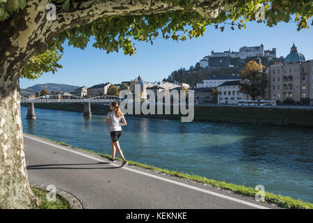 Salzbourg, Joggerin an der Salzach, im Hintergrund die Festung Hohensalzburg - Salzbourg, le jogging le long des rives du fleuve Salzach, Château de Hohensalzburg Banque D'Images