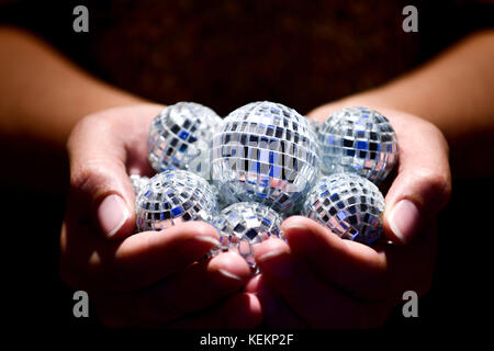 Close up of woman holding discoballs sous les projecteurs Banque D'Images
