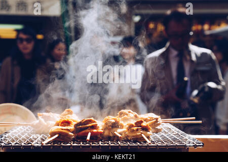 Fruits de mer grillés et de pétoncles mer ​​Urchin oeufs broche avec la fumée, de l'alimentation de rue japonais au marché aux poissons de Tsukiji, Japon. focus sélectif et insert. Banque D'Images