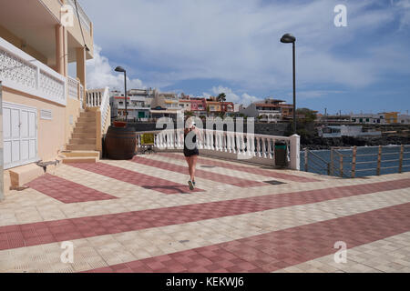 Woman jogging autour de front de mer à La Caleta, Tenerife, Canaries, Espagne. Banque D'Images