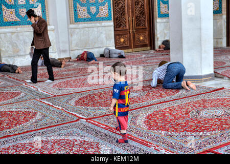 La province du Fars, Shiraz, Iran - 19 avril, 2017 : shah Cheragh Shrine, un petit garçon est en train de parler sur un téléphone mobile dans la cour intérieure de la mosquée, Nea Banque D'Images