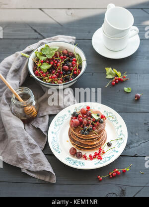 Petit déjeuner. de sarrasin avec les baies fraîches et de miel sur plaque rustique sur table en bois noir Banque D'Images