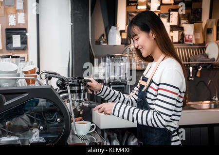 Les femmes de l'Asie de l'aire de préparation de l'usure barista café menu pour le client au comptoir bar,café concept entreprise propriétaire souriant, nourriture et service de boissons Banque D'Images