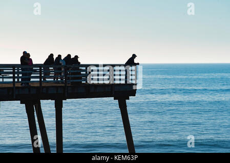Un groupe de personnes se profile sur Pismo State Beach Pier Pismo, Californie Banque D'Images