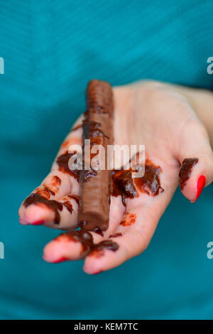 Barre de chocolat fondant dans la main Banque D'Images