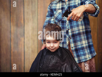 Un petit garçon est rognée dans le salon de coiffure Banque D'Images