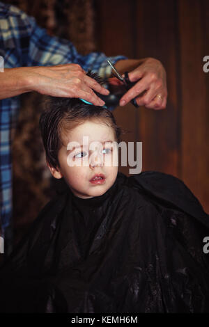 Un petit garçon est rognée dans le salon de coiffure Banque D'Images